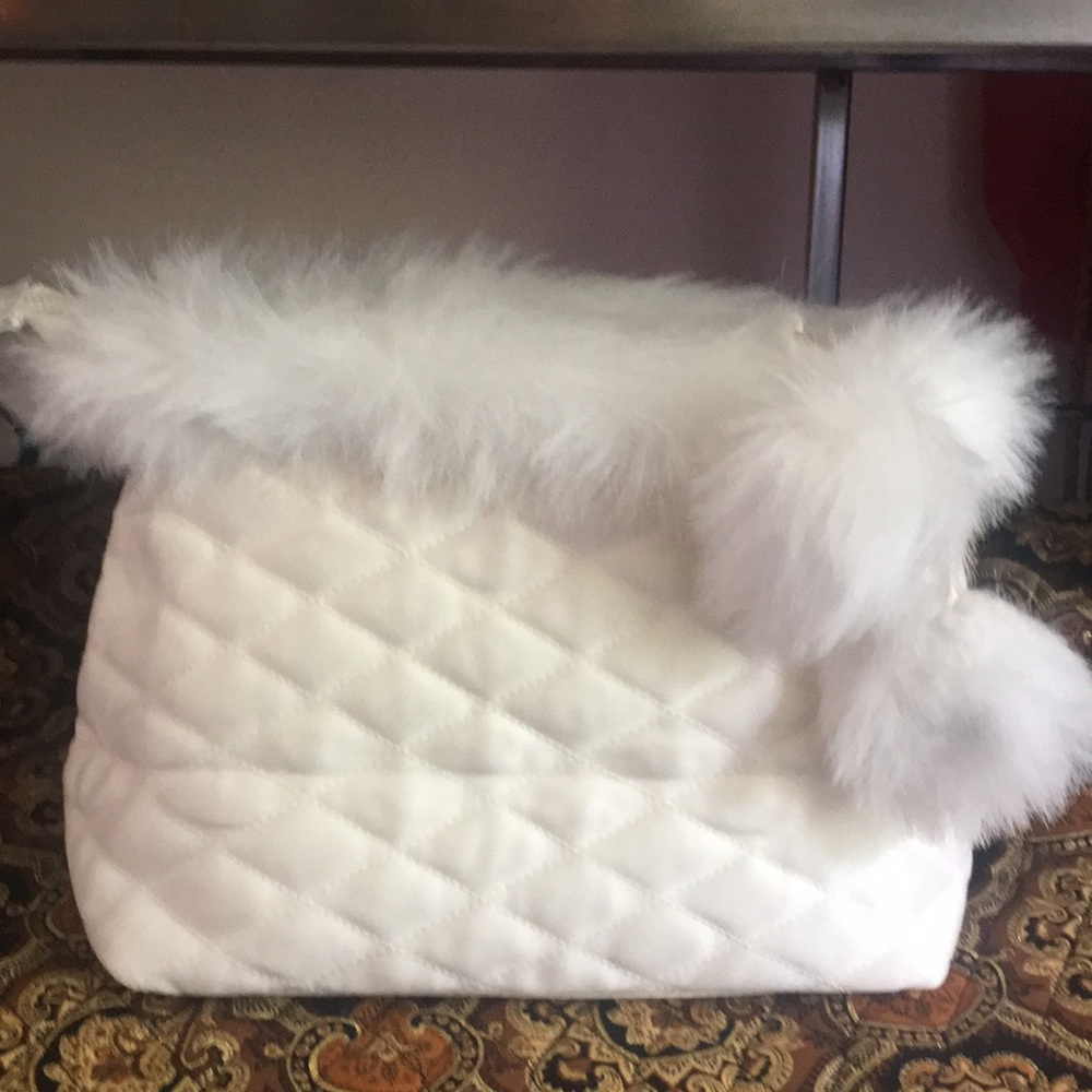 Quilted cream colored travel bag with Pompoms.